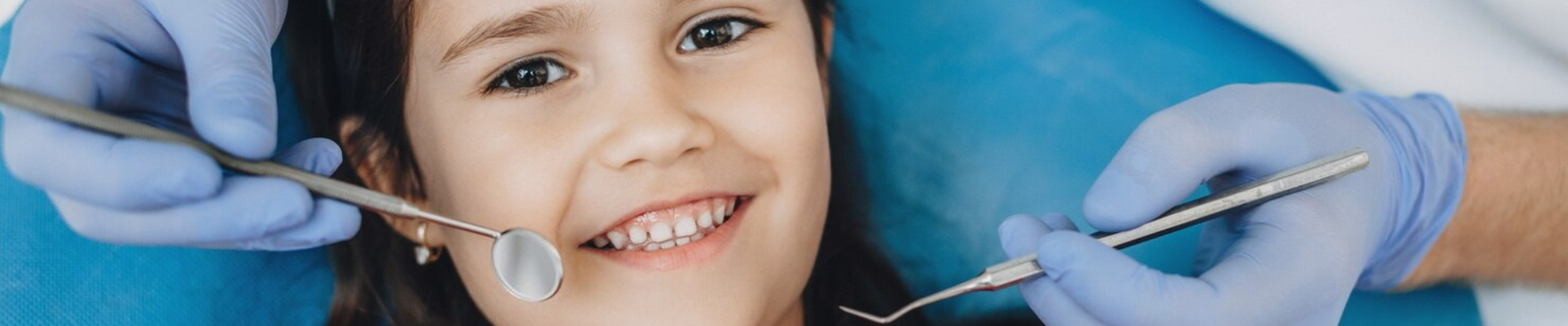 A dentist checking a smiling kid
